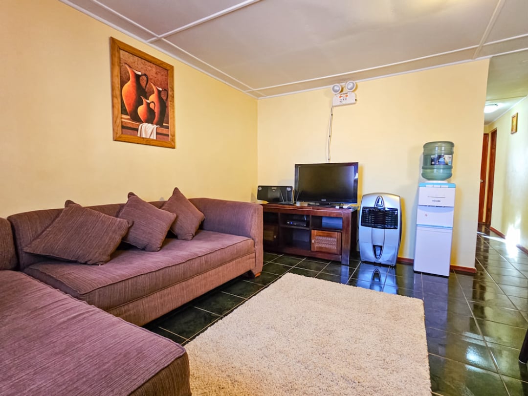 Living room of the Family Bungalow with corner sofa, TV and water dispenser
