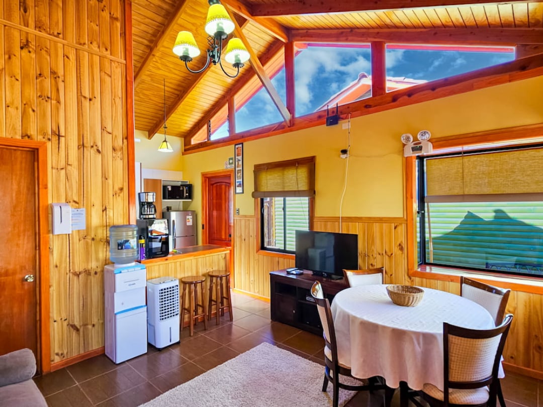 Round dining table, TV and equipped kitchen under the high ceiling of the Superior Bungalow