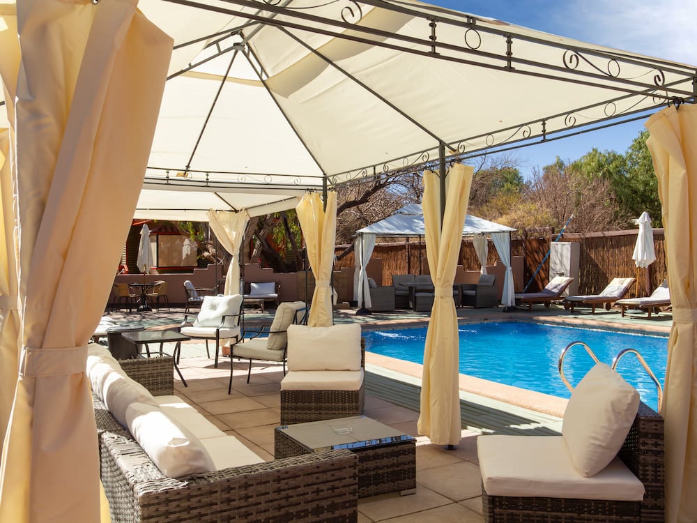 Lounge area under an awning by the pool