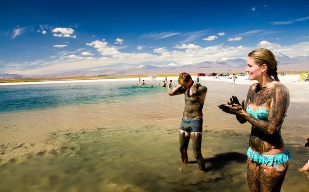 Bathers covered in salty mud on the shore of Laguna Cejar