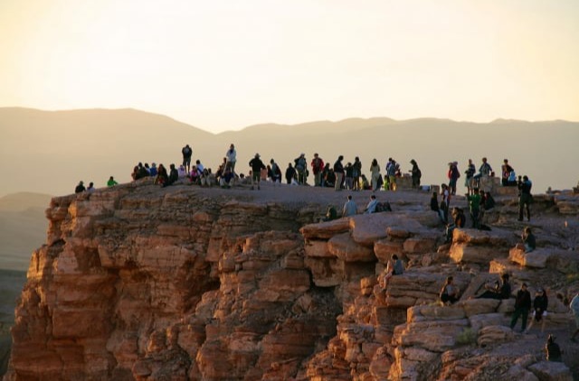 Visitors at the edge of the Moon Valley viewpoint at sunset