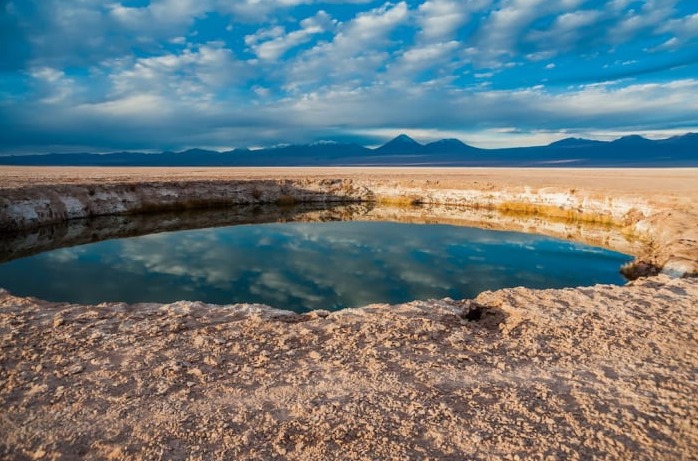 Ojos del Salar water hole with the mountains in the background
