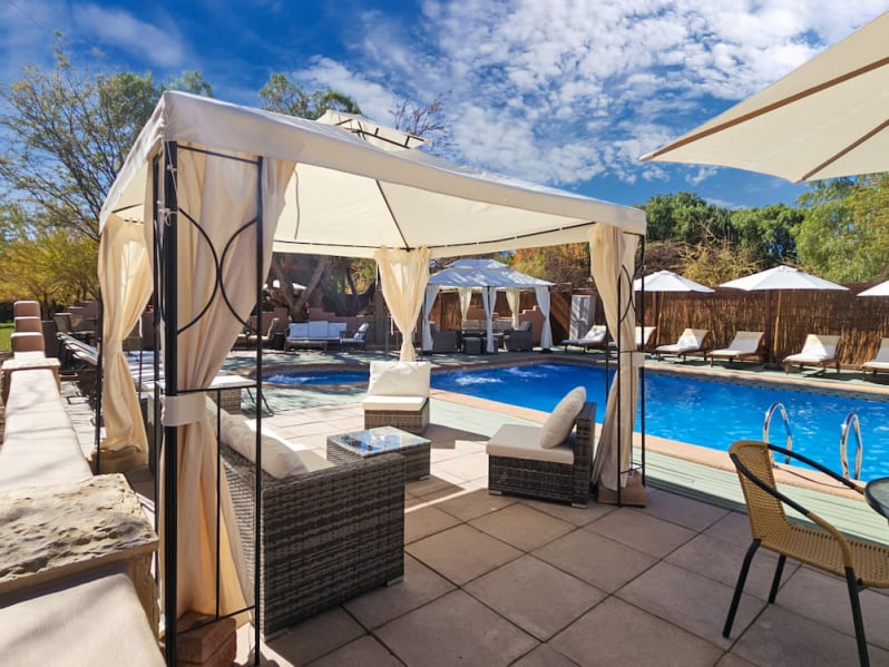Pergola with armchairs by the pool at Lodge Ancar Atacama