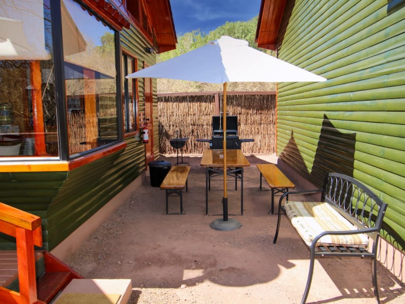 Terrace next to a cabin, with table, parasol and grill