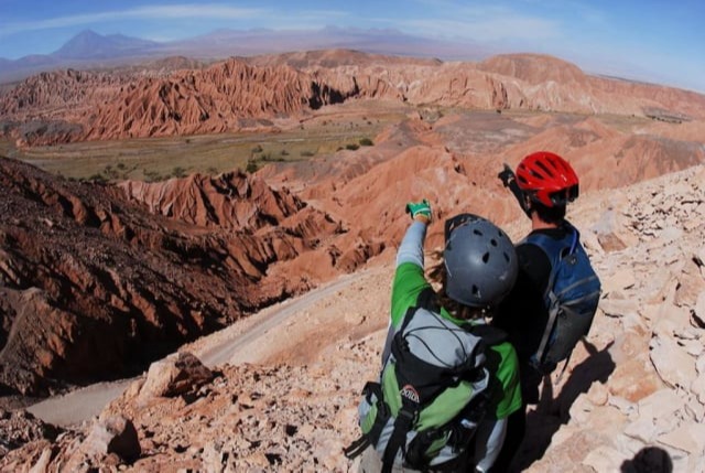 Cyclists in helmets looking at the hills of Valle de Catarpe